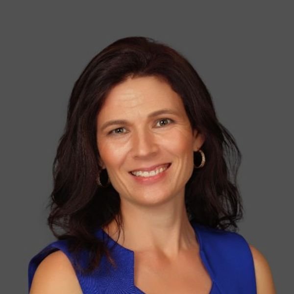 Glenda Colvin, smiling woman with dark hair wearing a blue sleeveless top