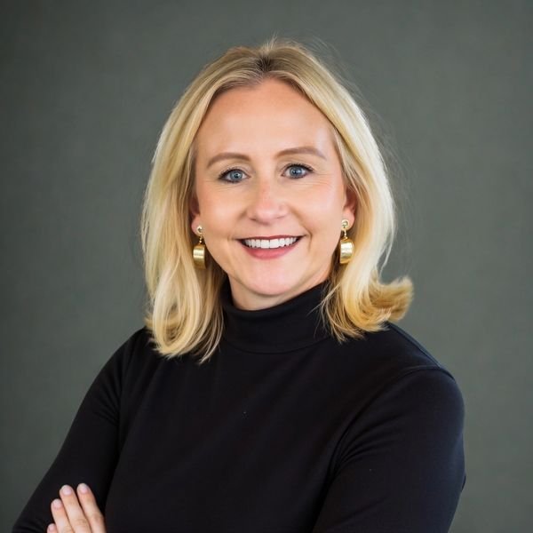Kelly M. Smith, professional woman with blonde hair in a black turtleneck